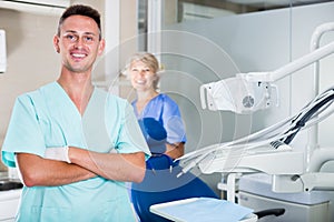 Male dentist in dental office with hands crossed