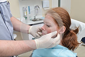 Male dentist examinating female patient at the clinic, Medical treatment at the dentist office.