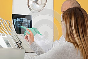 Male dentist examining radiography