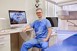 Dentist looking at teeth x-ray on the computer in a dentist office.