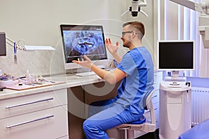 Dentist looking at teeth x-ray on the computer in a dentist office.