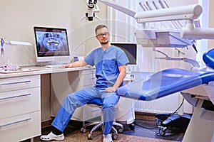 Dentist looking at teeth x-ray on the computer in a dentist office.