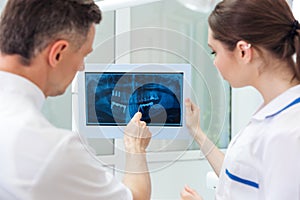 Male dentist showing something on the computer monitor