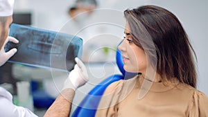 Male dentist showing teeth x ray mouth cavity condition and treatment. Shot with RED camera in 4K