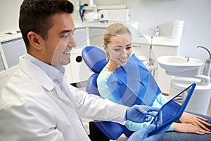 Male dentist with tablet pc and woman patient