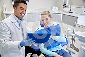 Male dentist with tablet pc and woman patient