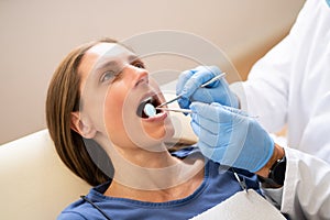 Male Dentist Treating Teeth Of Young Pregnant Woman