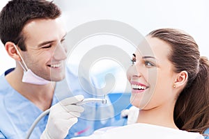 Male dentist and woman in dentistÃ¢â¬â¢s office photo