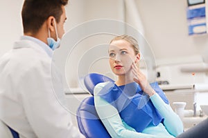 Male dentist with woman patient at clinic