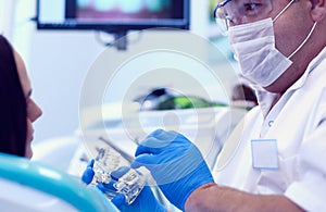 Male dentists examining and working on young female patient.Dentist`s office.