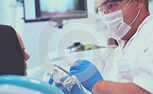 Male dentists examining and working on young female patient.Dentist's office.