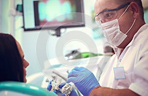Male dentists examining and working on young female patient.Dentist's office.