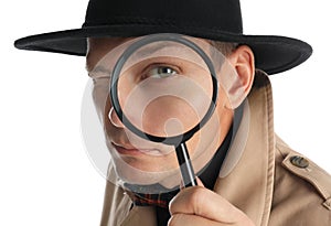 Male detective looking through magnifying glass on white background