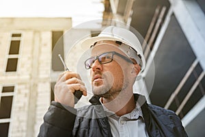 Male developer or engineer wearing white safety hardhat using w
