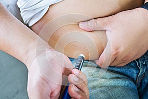 Male diabetes patient injecting insulin in his abdomen area photo