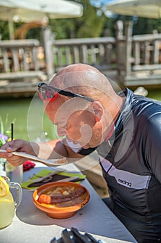 Male dining outdoors on a lake after a bike tour around Lake Bloke in Nova Vas, Slovenia