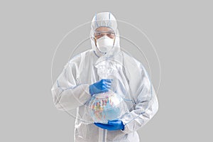 Male disinfector in protective suit holds globe