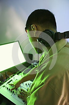 Male DJ using mixing equipment.