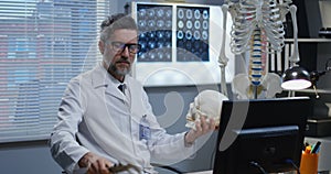 Male doctor analyzing human skeleton model
