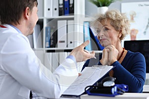 Male doctor asks an elderly lady about health