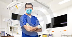 male doctor in blue uniform, mask and gloves