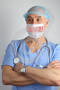 Male doctor in blue uniform with a stethoscope in a protective mask with the word coronavirus