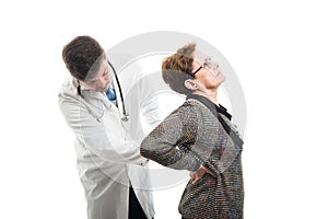 Male doctor checking female senior patient back