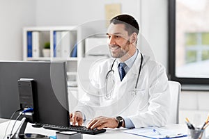 Male doctor with computer working at hospital