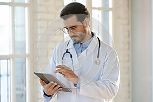 Male doctor consult client online using tablet