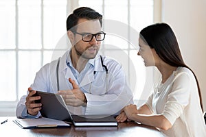 Male doctor consult female patient using tablet