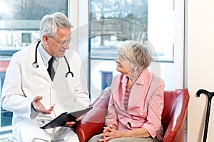 Male doctor in consultation with a senior patient photo