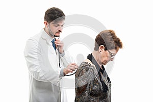 Male doctor consulting female senior patient with stethoscope