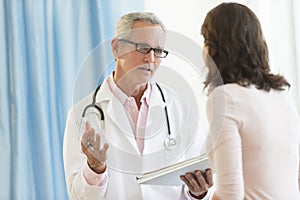 Male Doctor Discussing With Patient In Clinic