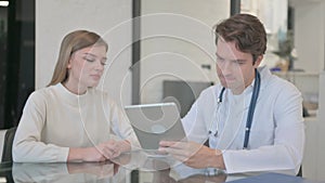 Male Doctor Discussing Treatment with Patient on Digital Tablet