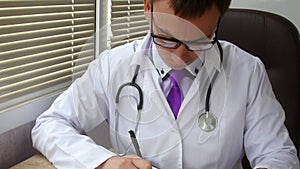 Male doctor doing paperwork in the office.