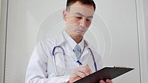 Male doctor doing paperwork in the office.