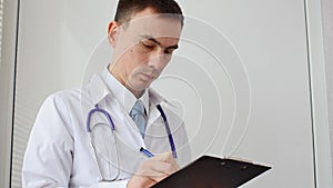 Male doctor doing paperwork in the office.
