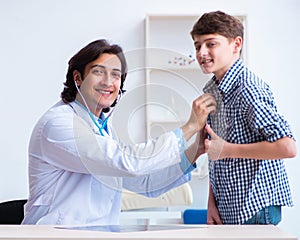 Male doctor examining boy by stethoscope