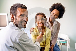 Male doctor examining a child patient in a hospital