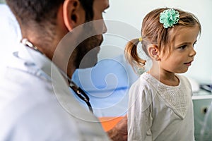 Male doctor examining a child patient in a hospital