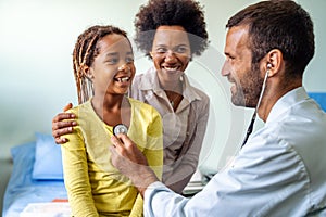 Male doctor examining a child patient in a hospital