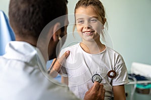 Male doctor examining a child patient in a hospital