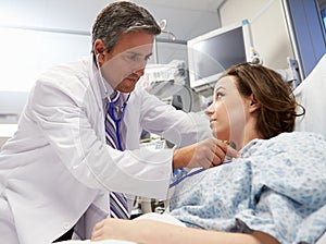 Male Doctor Examining Female Patient In Emergency Room