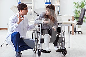 The male doctor examining female patient on wheelchair