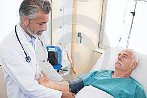 Male doctor examining senior man in hospital