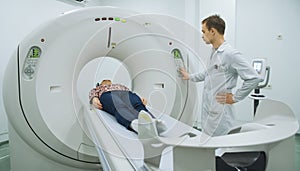 Male doctor exminating woman on mri machine