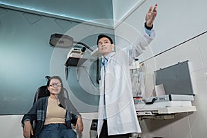 a male doctor is explaining the process of an eye health examination to a female patient