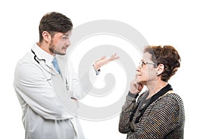 Male doctor explaining something to senior female patient