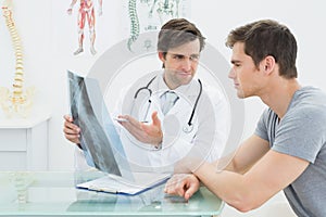 Male doctor explaining spine xray to patient