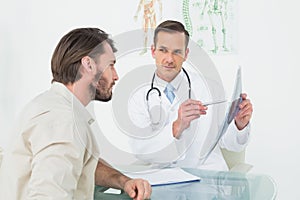 Male doctor explaining spine xray to patient